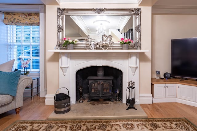 This stunning fireplace in the living room has a limestone hearth, with an inset multi-fuel stove,