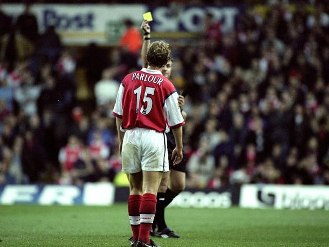 Arsenal's receives a yellow card from referee Gary Willard for a foul.