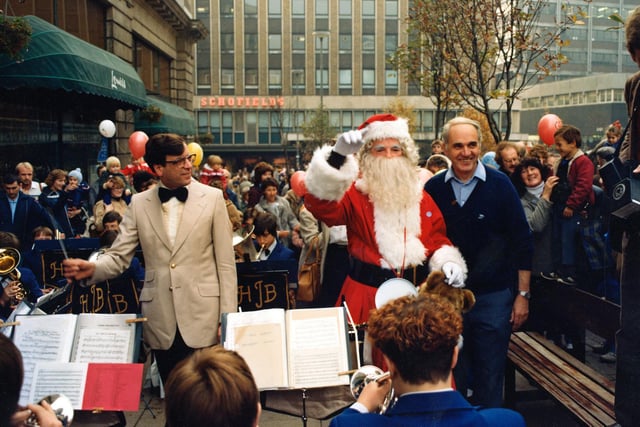Santa receives smiles from the crowd as he helps conduct the jazz band.