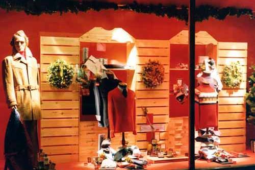 A Christmas themed window display possibly dating from the late 1970s early 1980s. Various items of mens' clothing, gifts and toiletries are displayed in front of a pine background designed to simulate a furniture unit with shelves and drawers