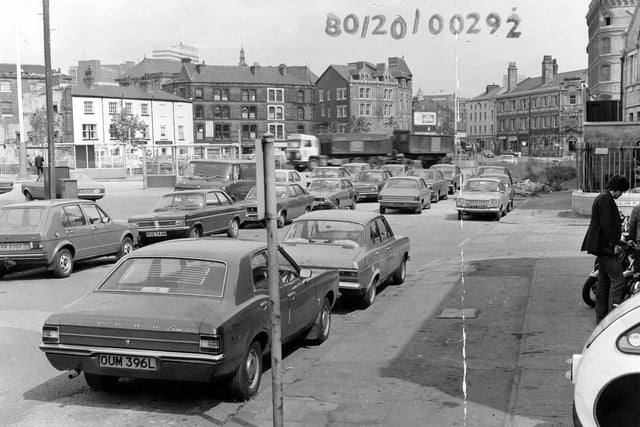 Looking north along Hunslet Lane, seen from Tetley's Brewery, in August 1980. On the right, a man is looking at motorbikes on display outside Motor Cycle Spares. Next to this is the junction with Salem Place, with Salem Congregational Church beyond. Further along are offices of the British Waterways Board. On the left, bus shelters can be seen in front of the Red Lion public house.