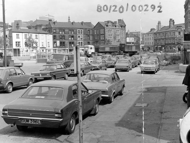Looking north along Hunslet Lane, seen from Tetley's Brewery, in August 1980. On the right, a man is looking at motorbikes on display outside Motor Cycle Spares. Next to this is the junction with Salem Place, with Salem Congregational Church beyond. Further along are offices of the British Waterways Board. On the left, bus shelters can be seen in front of the Red Lion public house.