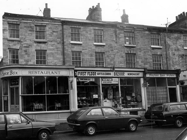 Shops on Boston Spa High Street in March 1980 featuring The Spice Box restaurant, Boston Office Supplies and Mayfair Hair Styles.