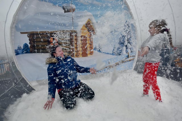 Doreen McGuire and Millie enjoy the giant snow globe.