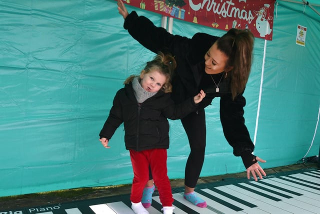 Playing the 'Big' piano at the Team Reece Winter Wonderland are Sophia May and her mum Shona.