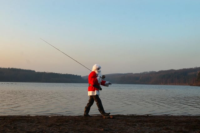 Father Christmas aka Washburn Valley fishing warden Colin Winterburn fly fishing at sunset on Swinsty reservoir.