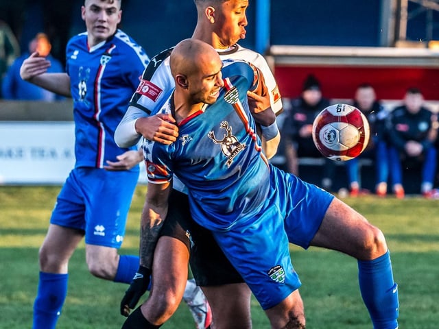 Whitby Town top scorer Jacob Hazel holds off a Grantham Town player in their 3-0 home win.

Photo by Brian Murfield