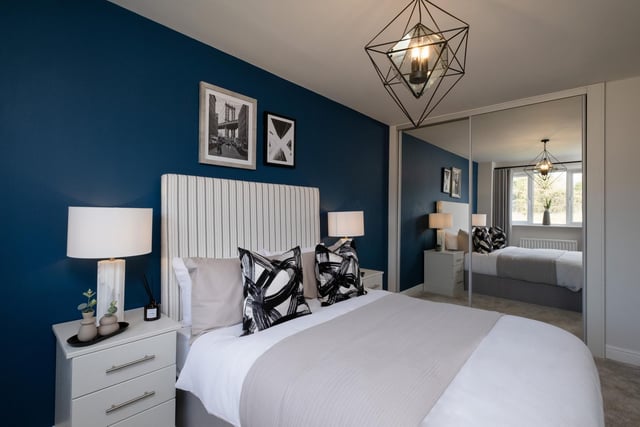 This example bedroom is painted in deep, dark blue tones which contrast with the bright, white furnishings.