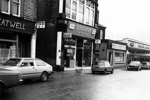 Morley's Queen Street in March 1981. On the left the stone building with decorative windows is the premises of Eatwell Chinese takeaway. In the centre is Sutcliffes T.V. Services. Also pictured is Norman Tempest & Son, Auctioneer, Valuer and Estate Agent  followed by the the D.F.S. Furniture Centre.