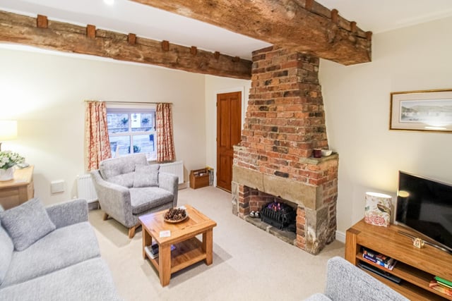 A brick fireplace with chimney breast is a focal point of the living room.