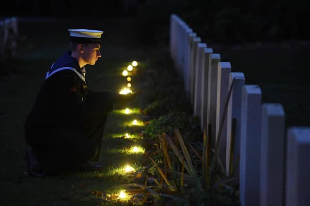 Oli Leeming-Sheppard from TS Cleopatra SCC laying tea lights by the war graves
