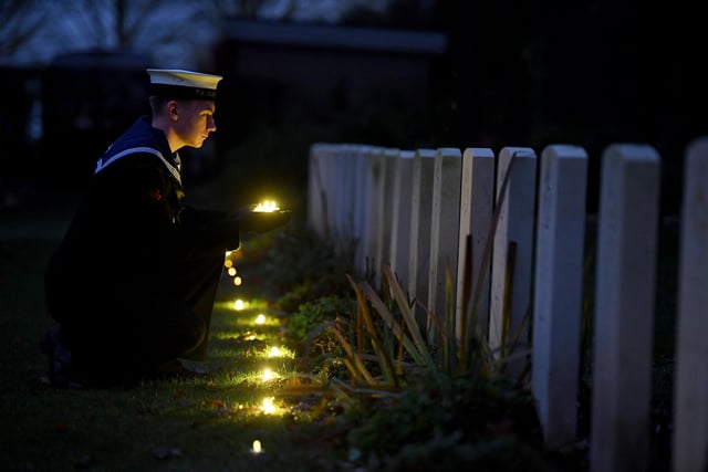 Oli Leeming-Sheppard from TS Cleopatra SCC laying tea lights by the war graves
