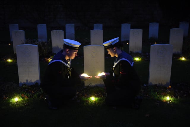 Oli Leeming-Sheppard and Laila Fairholm from TS Cleopatra SCC laying tea lights by the war graves