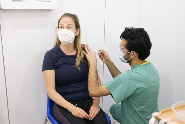 Amir Saemi (right) administers a booster coronavirus vaccine to Kayleigh Kitson (left)