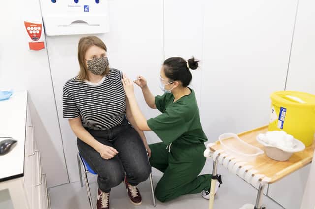 Wendy Geng (right) administers a booster coronavirus vaccine to Philippa Nall (left) at a Covid vaccination centre at Elland Road in Leeds