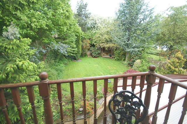 A lovely established rear garden surrounded by trees and bushes.