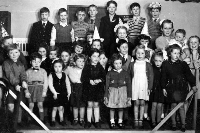 A group of children pose for a photograph during a Christmas party in Bramley circa 1952.