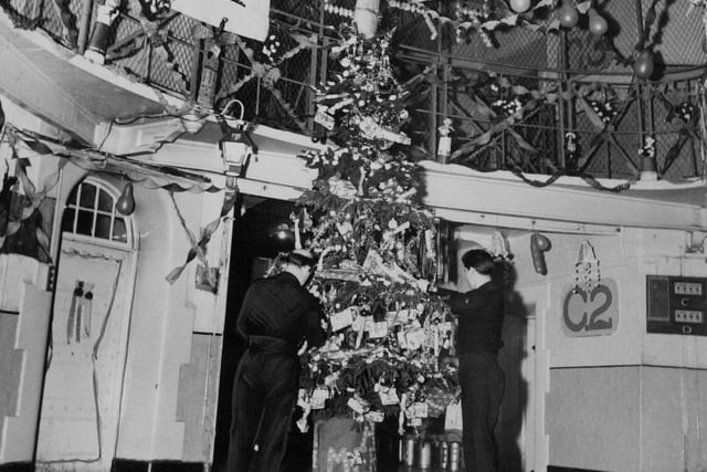 The decorated centre of Leeds Prison, Armley in December 1963. It is decorated with make believe parcels. Bare lamp bulbs are covered with cardboard lanterns.