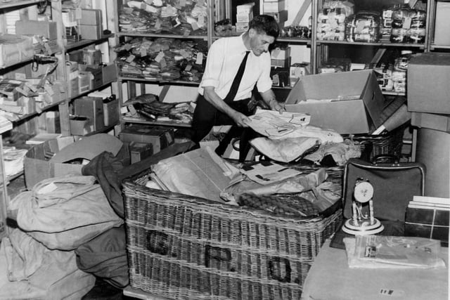 Dennis Alilson is pictured busy sorting through a mountain of damaged and undeliverable parcels in a storeroom at Leeds Head Post Office in December 1968.