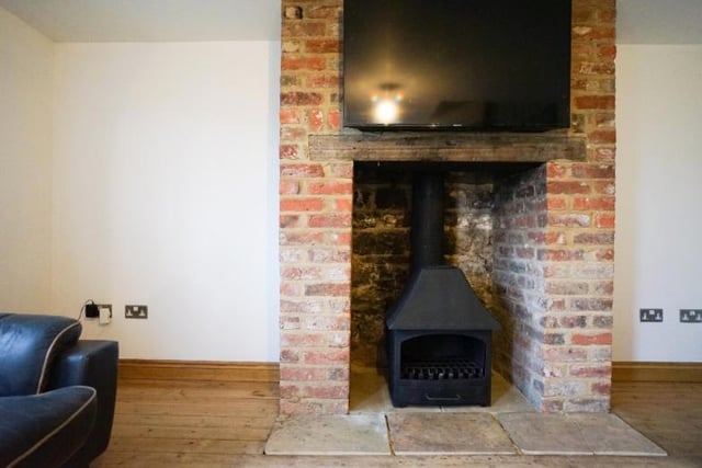 The brick fireplace housing the stove is a cosy centrepiece.