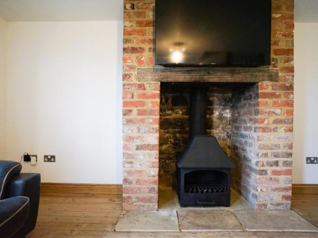 The brick fireplace housing the stove is a cosy centrepiece.