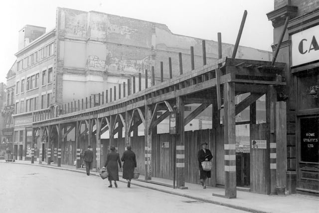 The extension to Woolworths store, which fronted onto Briggate in July 1940. White markings on wooden pillars are to warn people of their location in black-out. Small poster on right gives advice on air-raid precautions.
