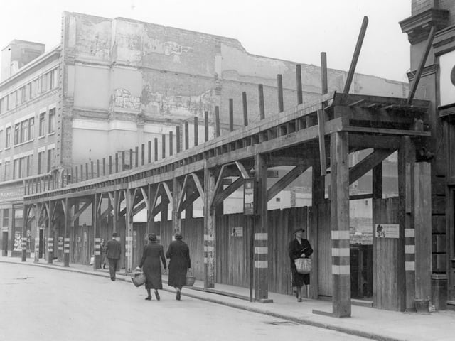 The extension to Woolworths store, which fronted onto Briggate in July 1940. White markings on wooden pillars are to warn people of their location in black-out. Small poster on right gives advice on air-raid precautions.