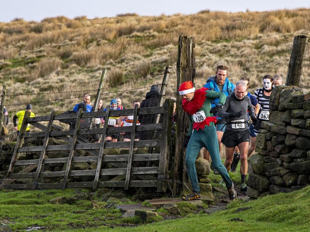 Carlos Bedson leads a group through a field gate