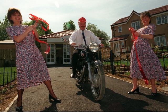 Site manager Andrew Bean rides his 1955 Matchless 350cc motor bike through the ribbon held by Margaret Maltby (left) and Anita Mitchell to officially open the new Taywood Homes site at Spring Park, Pudsey, in May 1998.