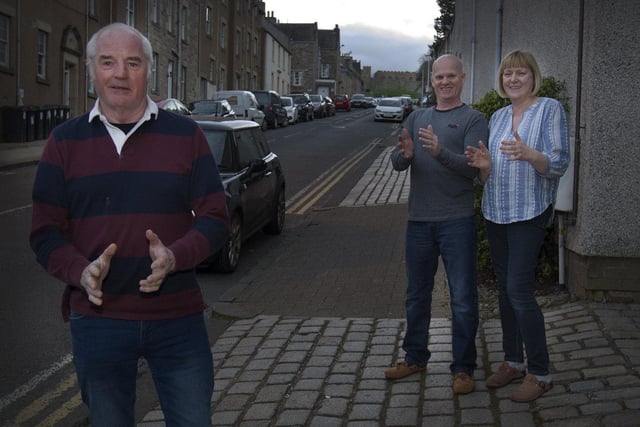 Len Wyse with neighbours Michael and Jen Reid clapping on Castlegate, Jedburgh.