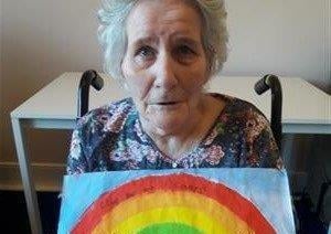 Hannah Mckay with a handpainted rainbow posted by children to Bonchester Bridge Care Home.