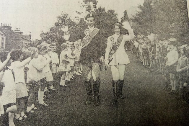 The Braw Lad and Lass walk down the drive of the Burgh School to the cheers of the young pupils.
