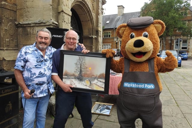 Barry Hale auctions one of his paintings with it's new owner Steve Doggett and Wicky Bear. Photo by Andrew Carpenter