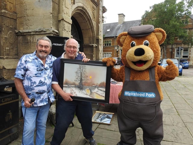 Barry Hale auctions one of his paintings with it's new owner Steve Doggett and Wicky Bear. Photo by Andrew Carpenter
