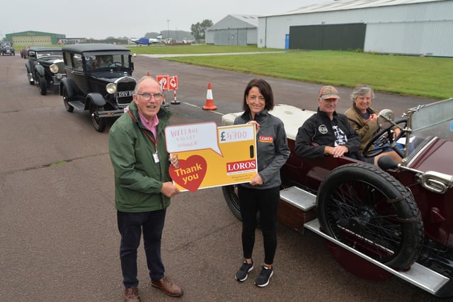 Organiser Andrew Duerden hands over £4,700 to Loros fundraiser Debbie Dickman during the start of the first classic car rally at Stoughton airport.