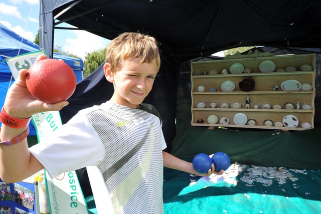 Sam Holland, 11, takes aim on the crockery smashing stall to raise funds for the Butterfly Hospice Trust.
