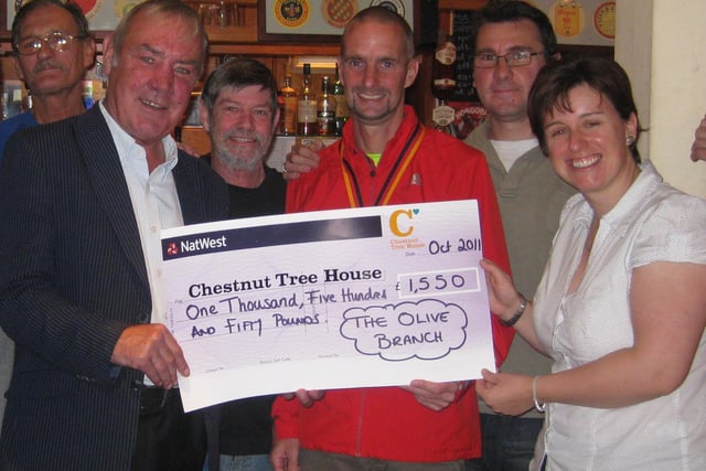 Alan Minter (front, left) and Lee Neumann (red jacket) present a cheque for £1,550 to Ali Unstead, of Chestnut Tree House, watched by Olive Branch landlord Doug Haw (second from right) and pub regulars