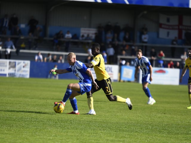 Former Kettering Town man Marcus Kelly, now a Nuneaton player, is tracked by Diamonds midfielder Jesse Akubuine