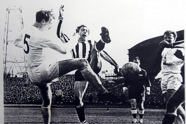 Tommy playing for his beloved Newcastle United against Leeds United in the old First Division. Tommy is challenging Jack Charlton for possession, while Leeds skipper Billy Bremner looks on.