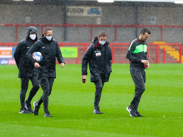 Officials inspect the pitch before the game