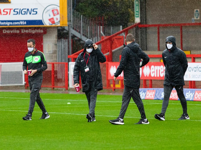 Officials inspect the pitch before the game