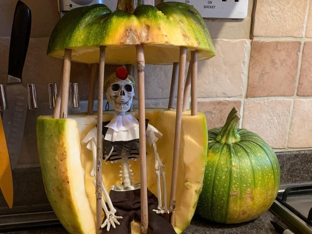 A rather unique take on traditional pumpkin carving - even the skeleton looks pleased with his prison.