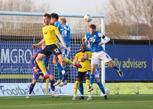 Jack Taylor of Peterborough United heads the ball clear from an Oxford United corner. Photo: Joe Dent/theposh.com.