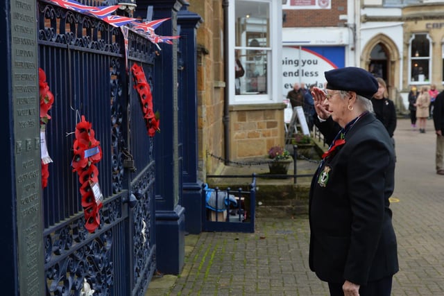 Pat Middleton of the Royal Naval Associaion lays a wreath on the memorial gates.
