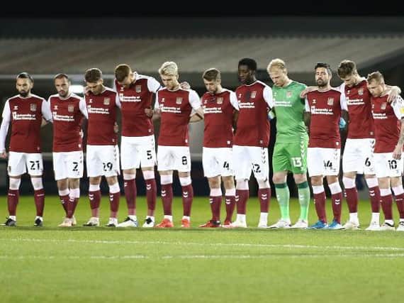 Cobblers players hold a minute's silence for Denis Casey. Pictures: Pete Norton