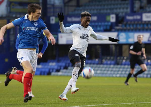 Siriki Dembele of Peterborough United in action with Sean Raggett of Portsmouth. Photo: Joe Dent/theposh.com.