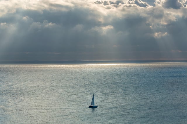 Yacht making its way past Beachy Head with a stormy sky in the background. Taken by Barry Davis with a Canon 5d. SUS-201215-110353001