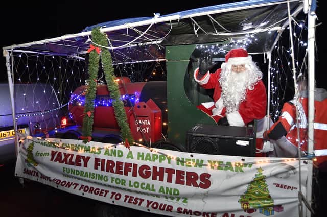 Firefighters and volunteers meeting residents of Yaxley as their Christmas sleigh tours the village EMN-201215-204755009
