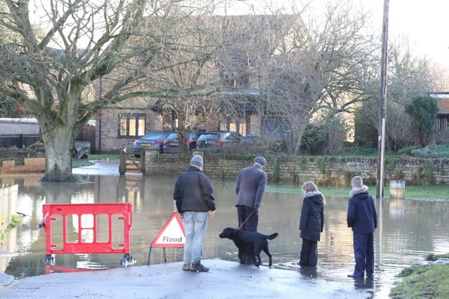 Onlookers survey the aftermath of the flood waters