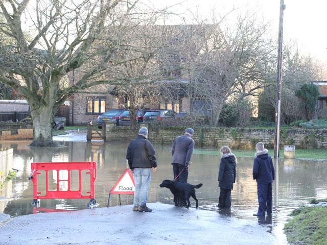 Onlookers survey the aftermath of the flood waters